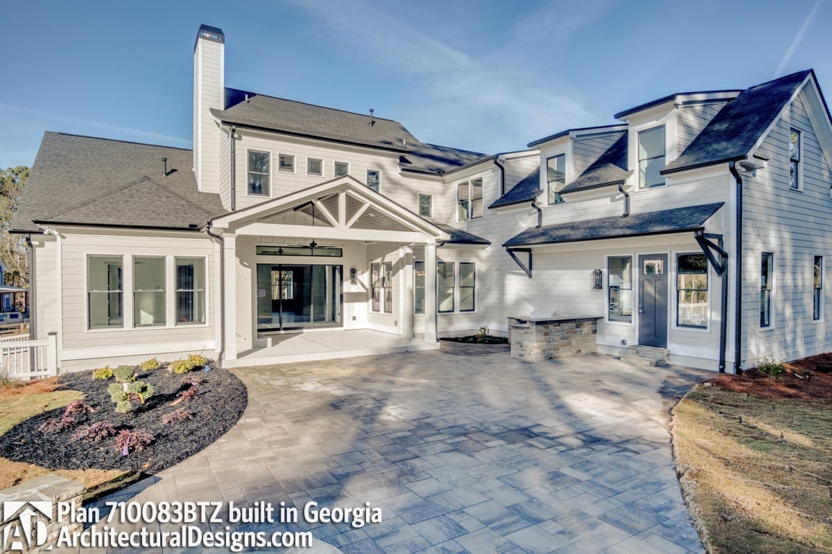 House plan exterior featuring a covered entryway with gables, multiple dormers, and an outdoor kitchen area.