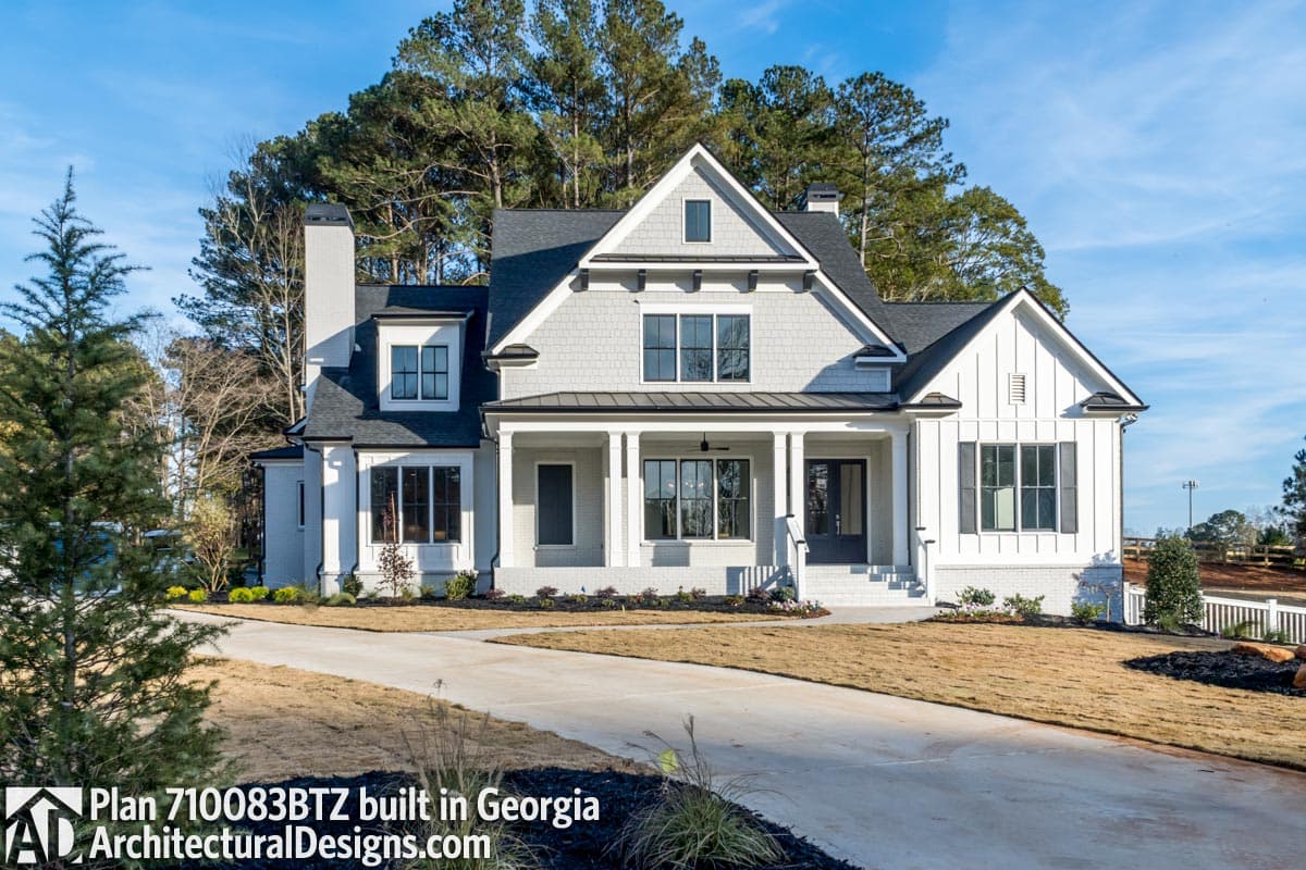 House plan exterior: Modern Farmhouse style, two stories, covered front porch with columns, gables, and a prominent chimney.