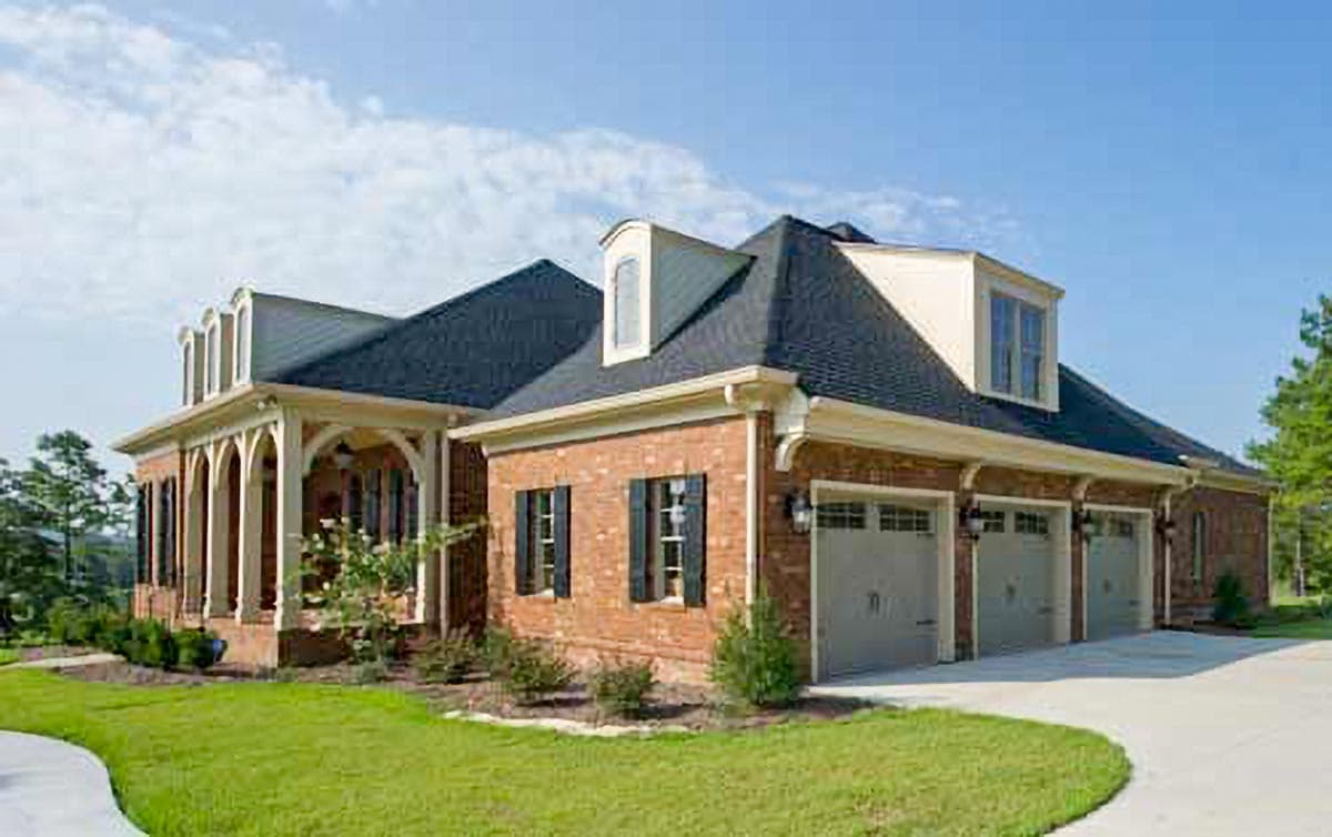 House plan exterior: brick, two stories, arched front porch, dormers, and a three-car garage.