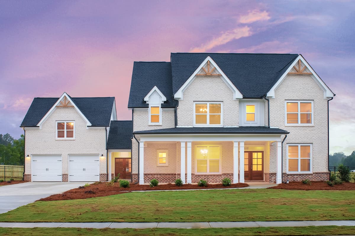 House plan exterior. Two-story home with a gabled roof, a front porch, and a detached garage with two bays and a matching roofline.