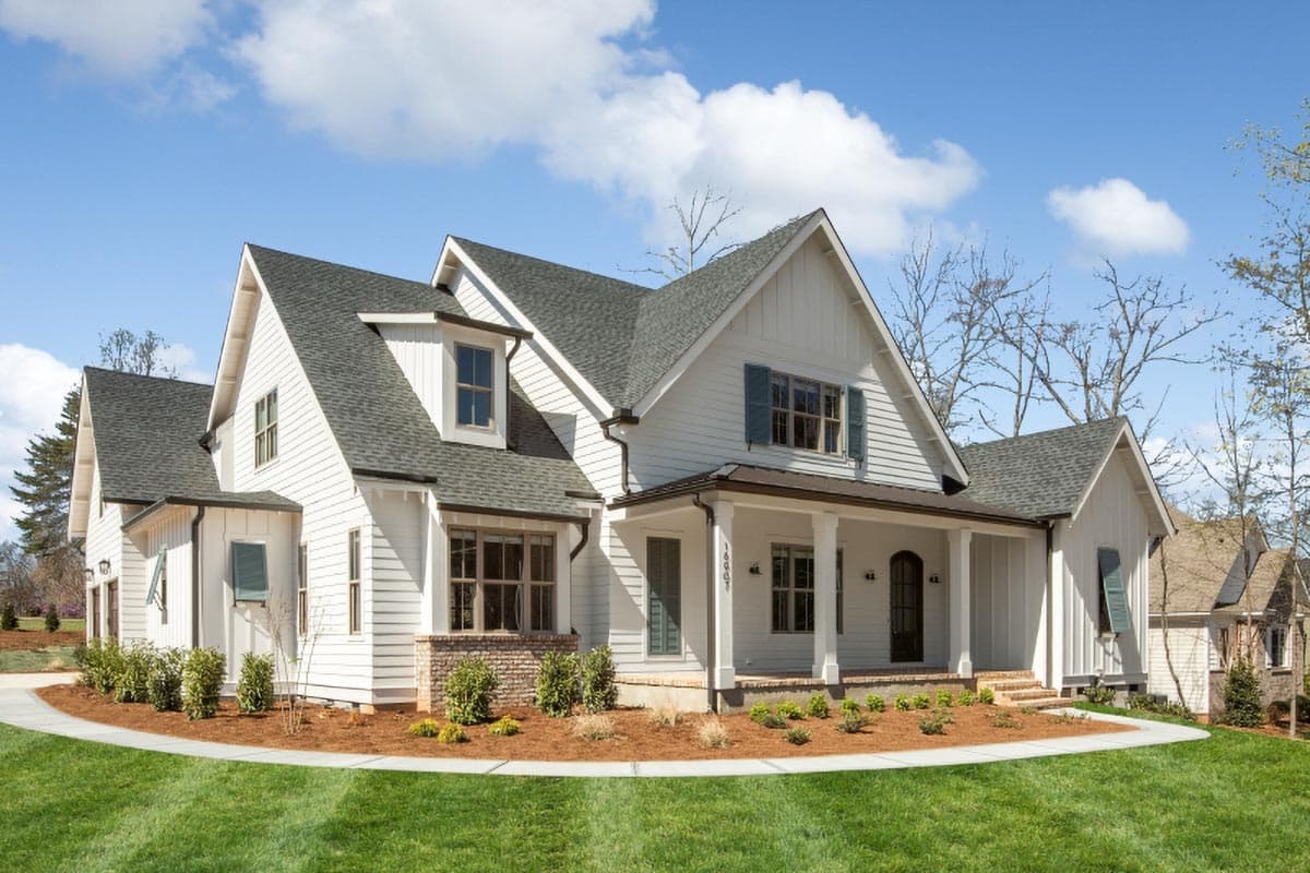 House plan exterior featuring a two-story farmhouse style, front porch with columns, multiple gables, and dormers.