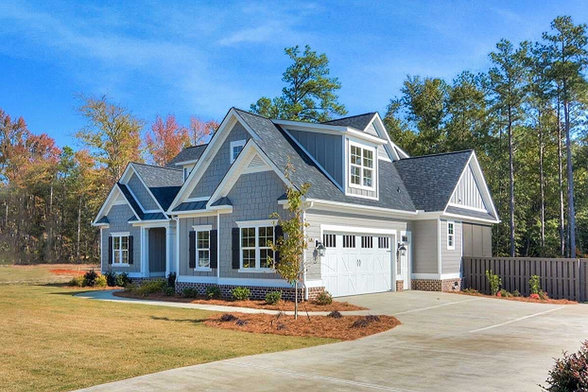 House plan exterior features gabled rooflines, dormer windows, side-entry garage, and mixed siding.