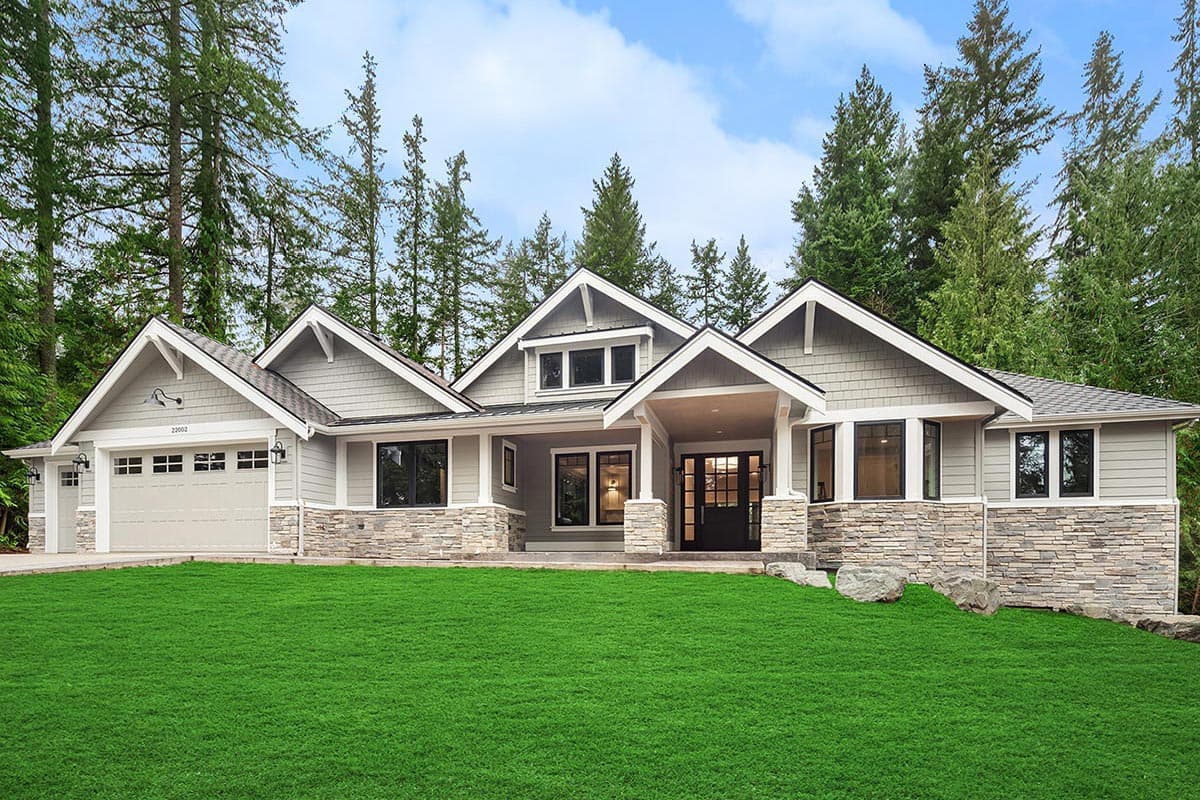 House plan exterior. Craftsman style, single story. Features include multiple gables, a covered entry, and a three-car garage.