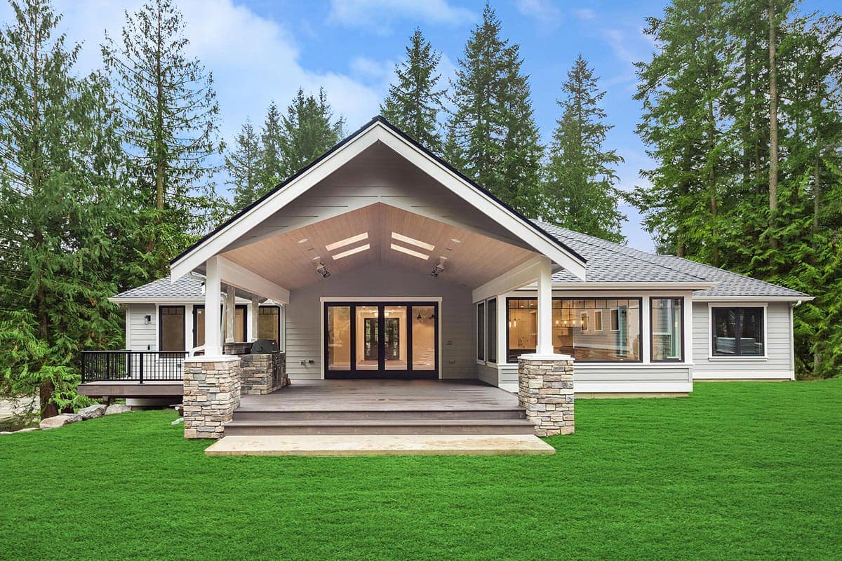 House plan exterior of a single-story home with a covered patio, stone accents, and large windows.