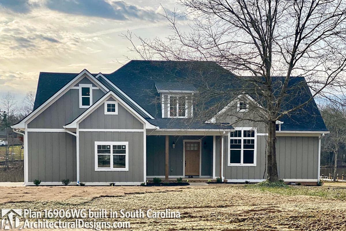 House plan exterior with gables, dormers, board-and-batten siding, and covered entry.