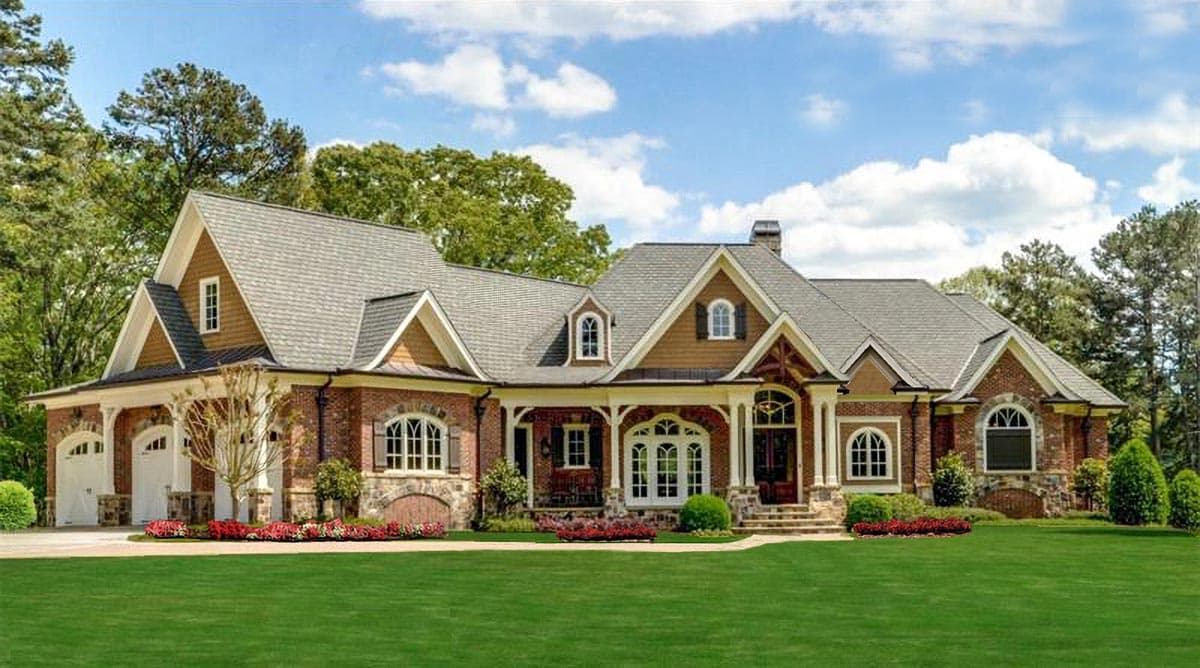 House plan exterior. Two-story, brick facade, with a covered porch, multiple gables, and a porte-cochère garage on the left side.