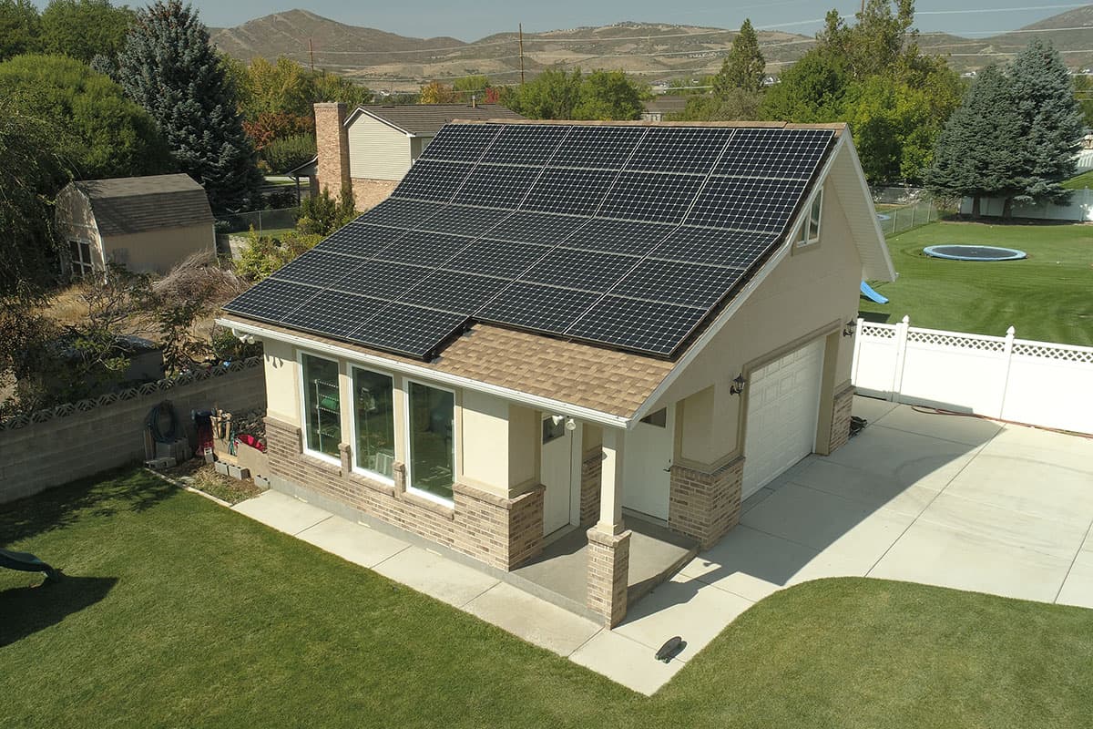 House plan exterior shows a two-story home with solar panels, attached garage, and a covered front entry with brick accents.
