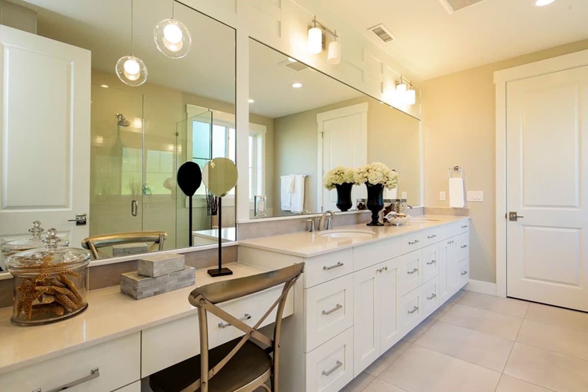 Bathroom with double vanity, large mirror, glass-enclosed shower, and decorative lighting.