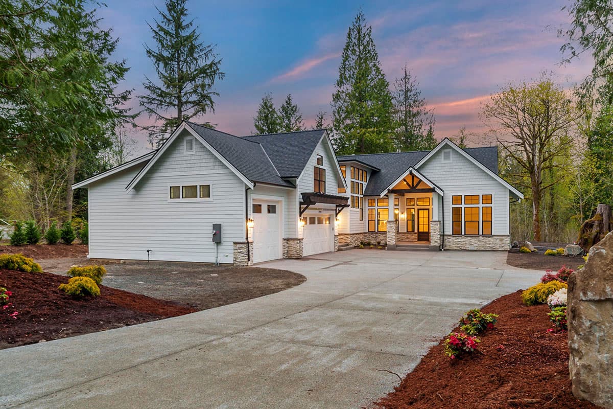 Modern Farmhouse house plan exterior with two-car garage, prominent gables, wood-accented entrance, and large windows.