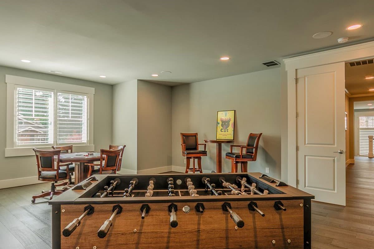 Recreation room with foosball table, card table, and bar stools.