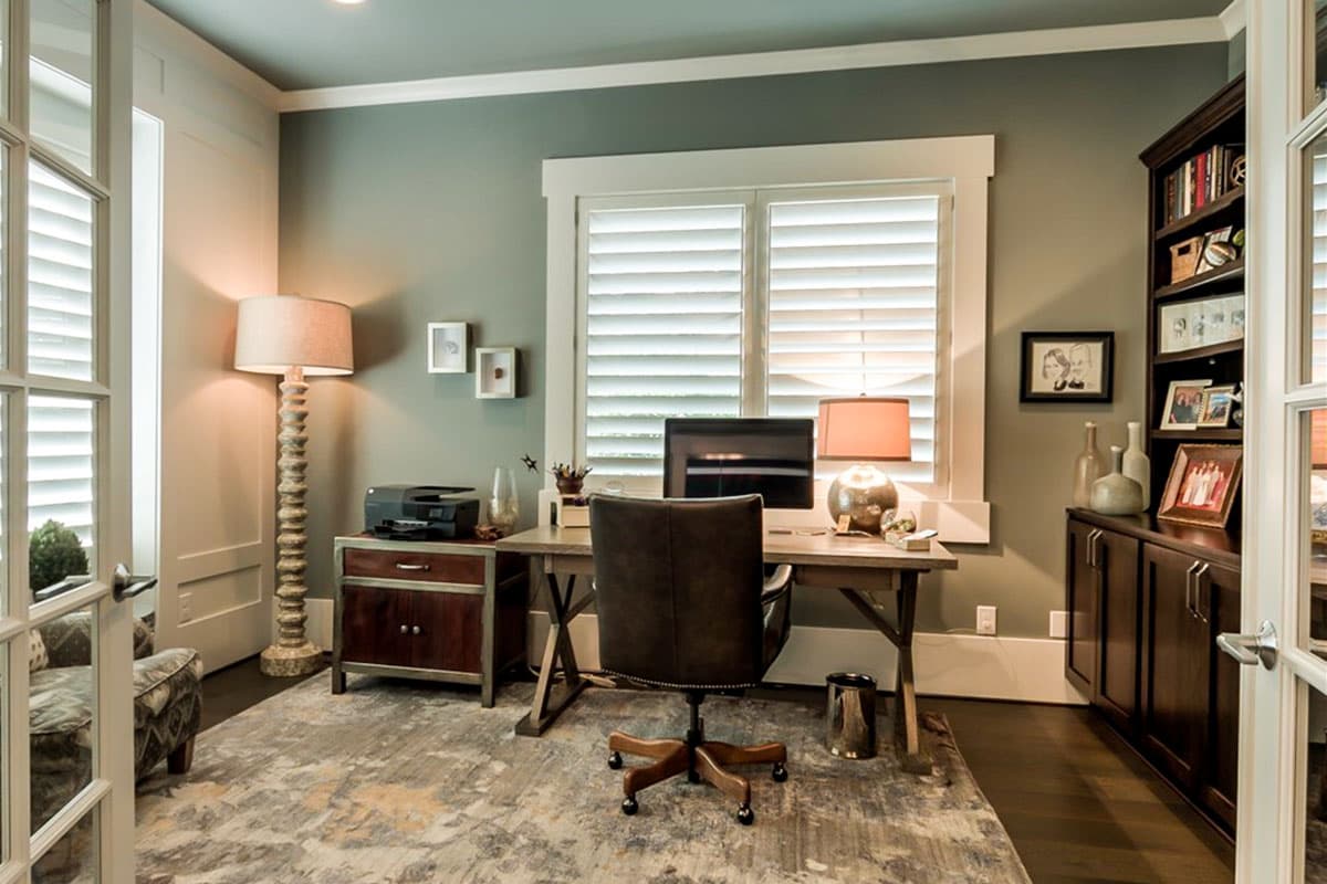 Home office with desk, chair, printer, and built-in bookcase. Interior view.