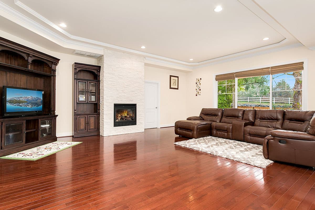 Living room with stacked stone fireplace, built-in entertainment center, and large sectional sofa.