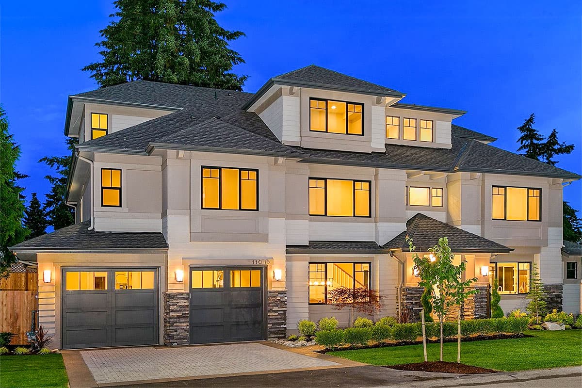 House plan exterior. Two-story, Modern style home. Features include a dual garage, multiple gables, and varied rooflines. Stone facade accents.