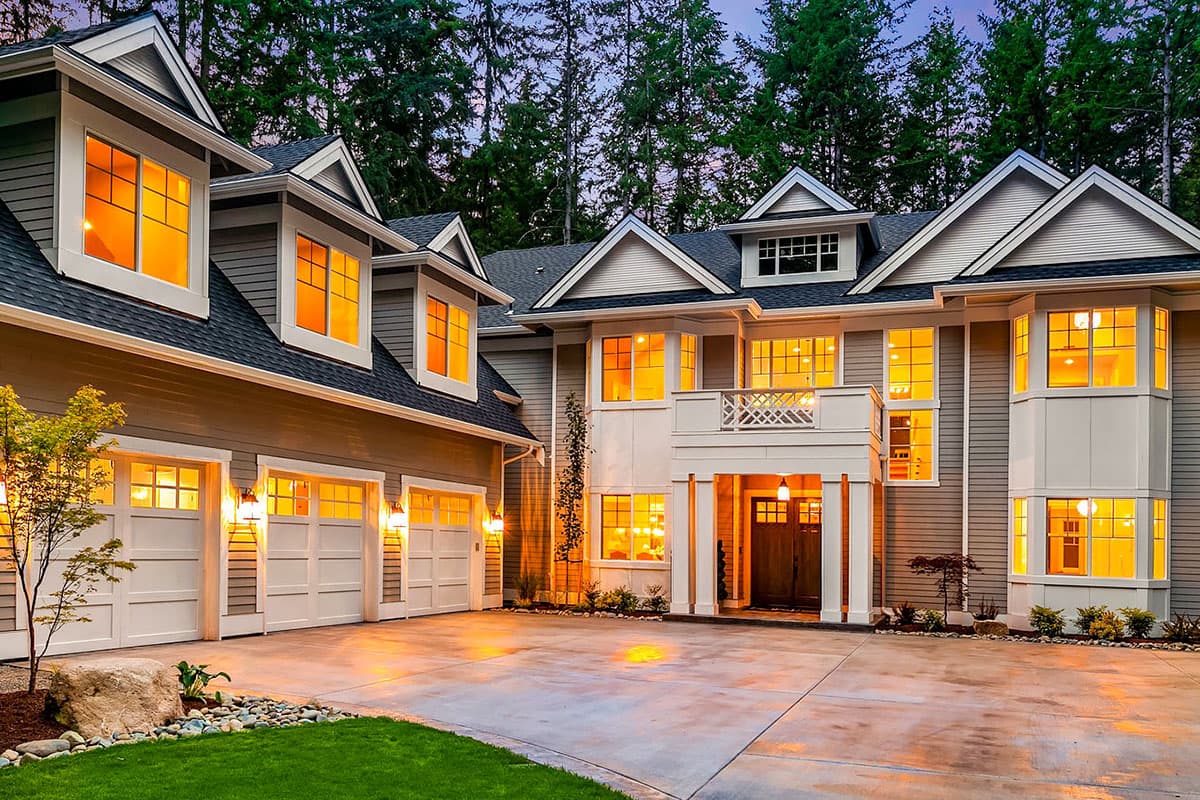 House plan exterior with three-car garage, covered entry, dormer windows, and multiple gables.