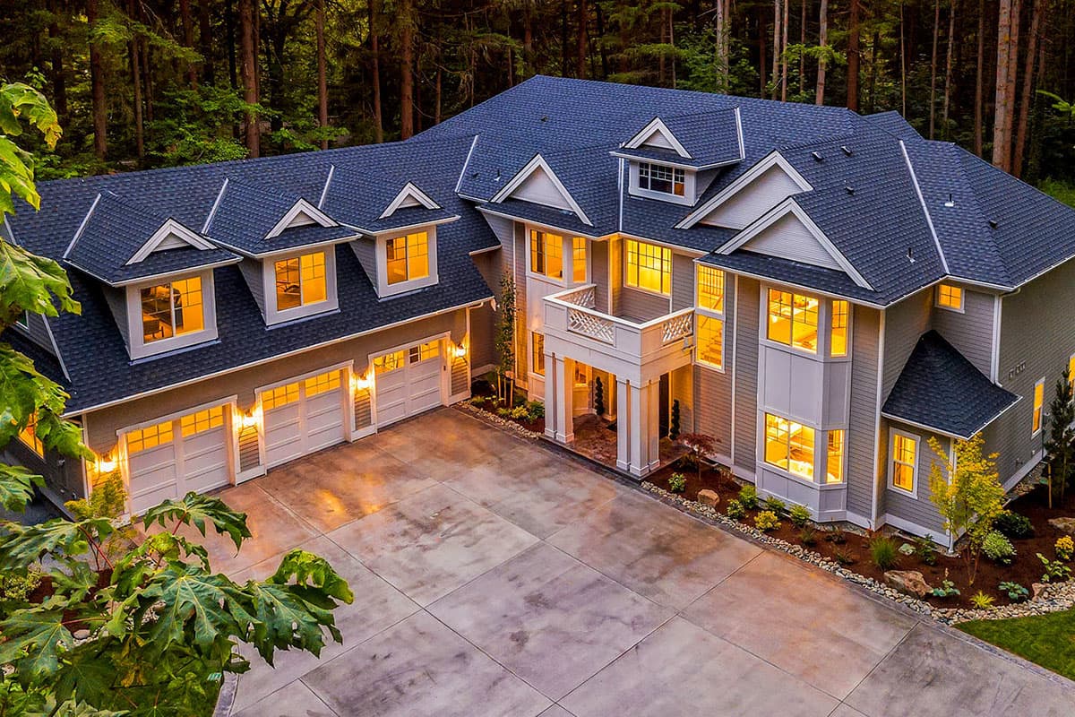 House plan exterior: Two-story home with multiple gables, dormers, a covered front porch, and a three-car garage.
