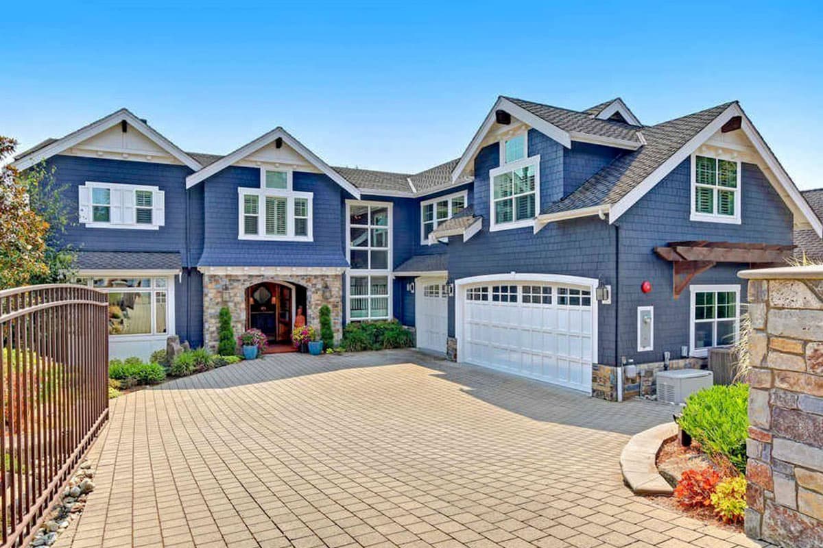 House plan exterior, two-story Craftsman with multiple gables, stone facade entry, and a side-entry garage.