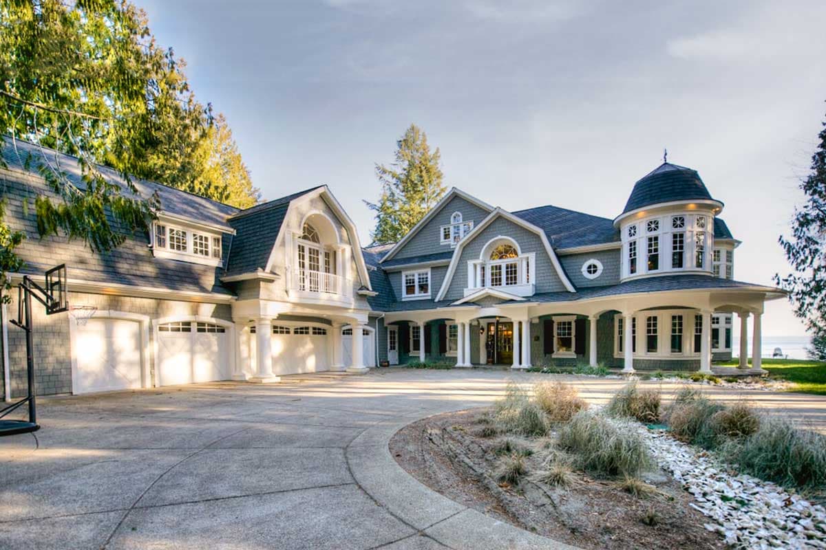 House plan exterior with multiple gables, a turret, and a covered porch. Features include a three-car garage and dormer windows. Two stories.