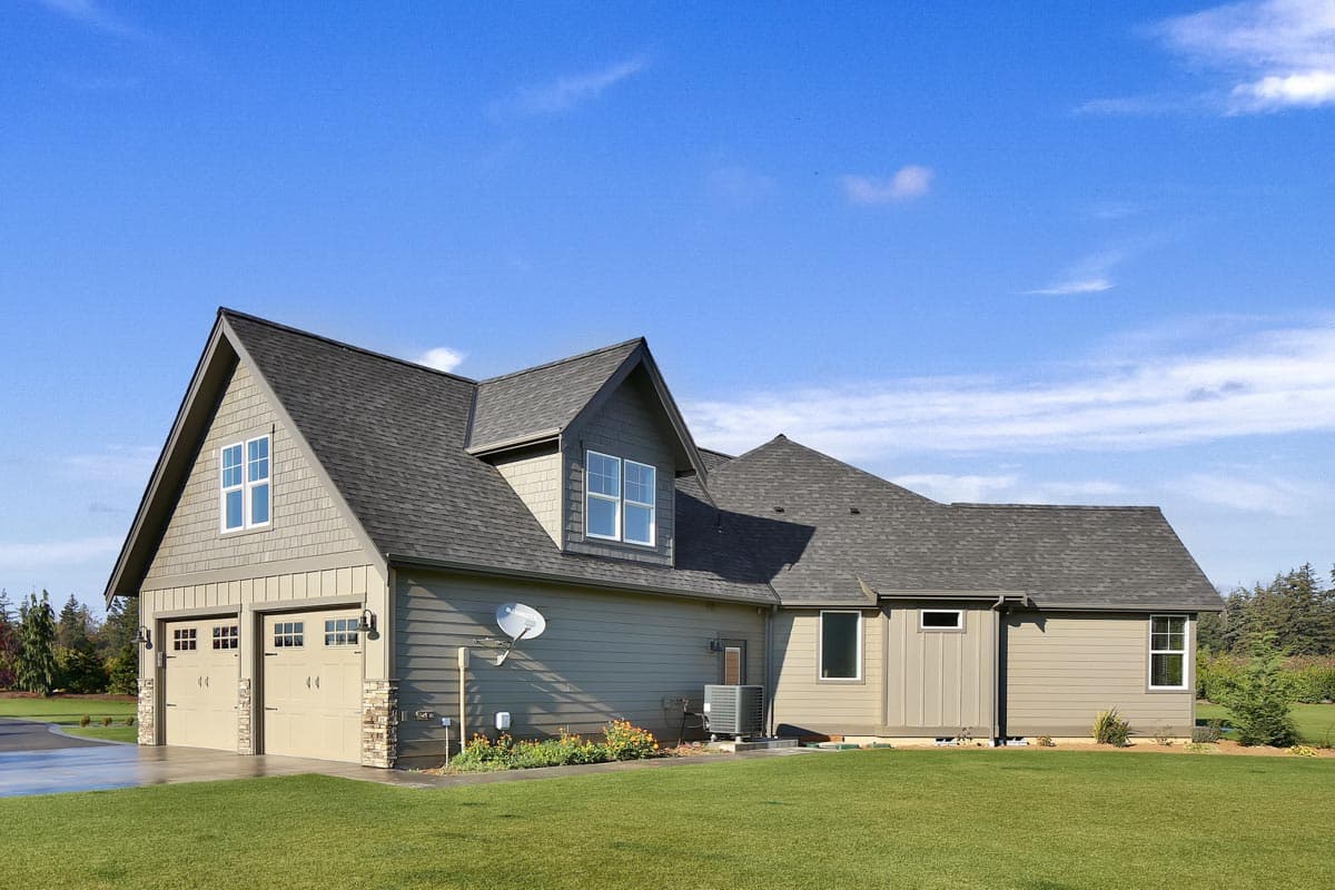 House plan exterior with a two-car garage, prominent gables, dormer, and varied siding.