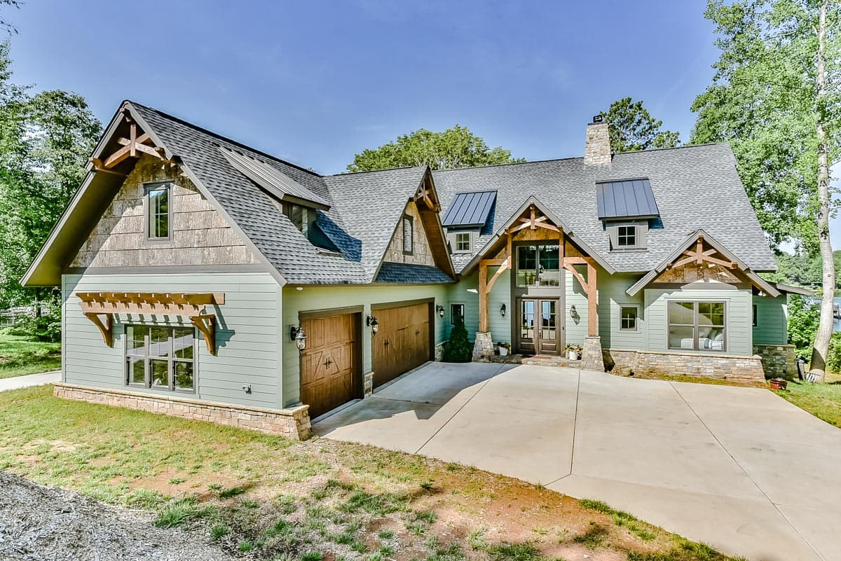 House plan exterior. Two-story home with Craftsman-style elements, multiple gables, a pergola, and a stone chimney.