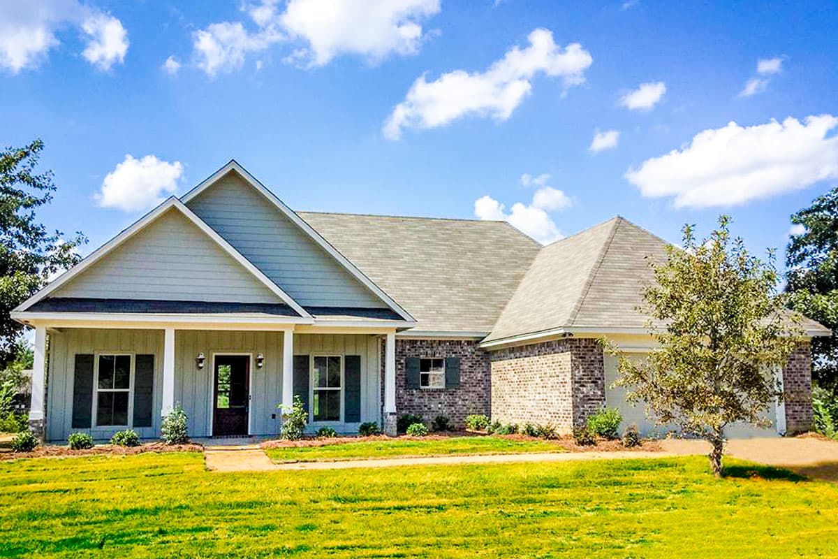 House plan exterior with Craftsman style, one story, and a front porch with gables and brick accents, and attached garage.
