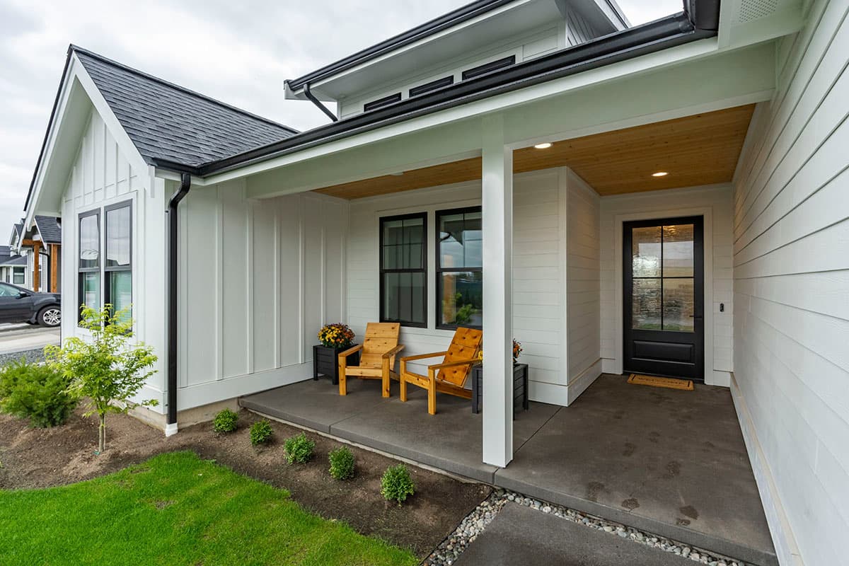 Modern Farmhouse house plan exterior with gabled roof, board and batten siding, and covered front porch with seating.
