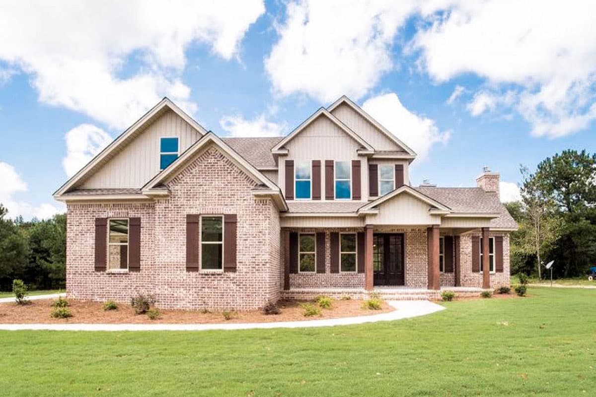 House plan exterior with brick facade, two stories, gable roof, front porch with columns, and multiple dormers.