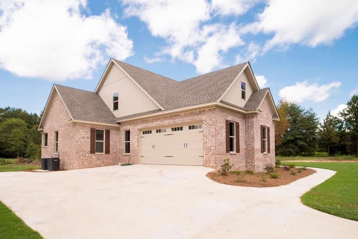 House plan exterior with brick facade, gable rooflines, side-entry garage, and dormer window.