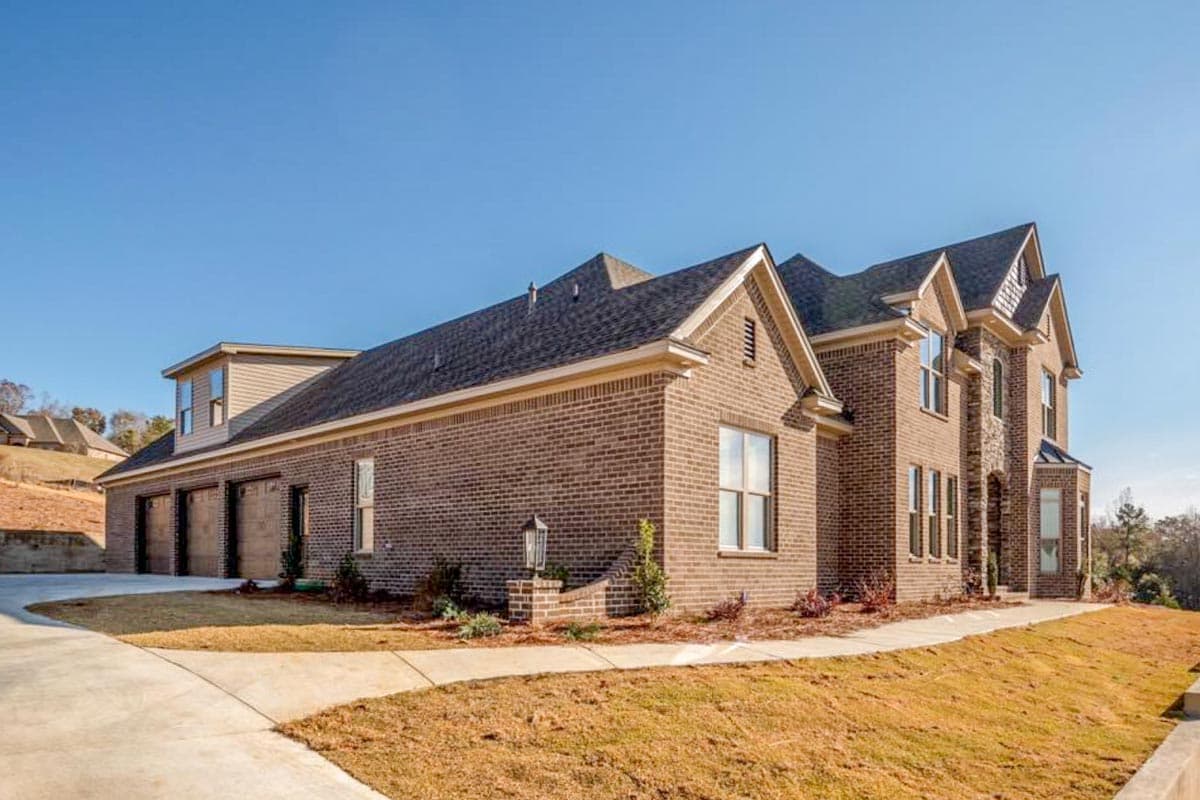 House plan exterior with brick facade, multi-story gables, and a five-car garage.