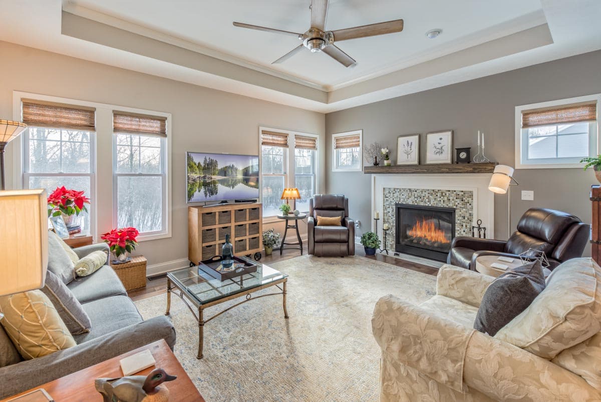 Living room with fireplace, media console, seating, and coffered ceiling.