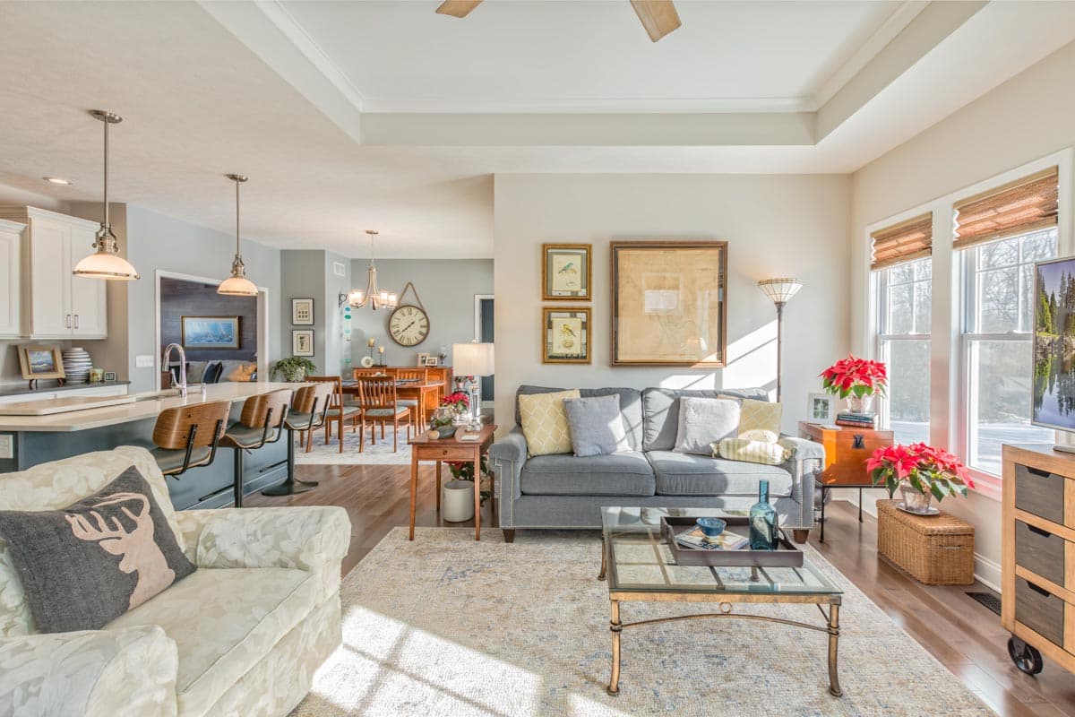 Open concept living area with kitchen island, dining area, and living room featuring a sofa and coffee table.