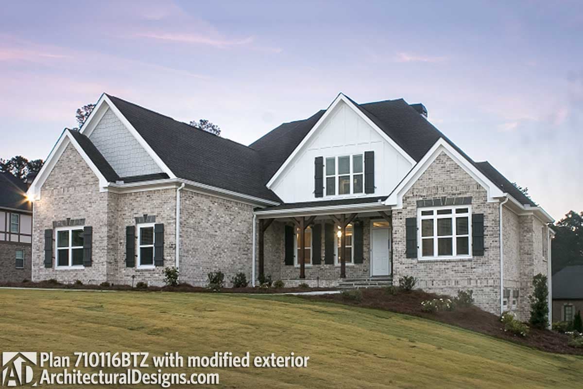 House plan exterior: One-story Modern Farmhouse with brick facade, covered front porch with wood supports, and gabled dormers.