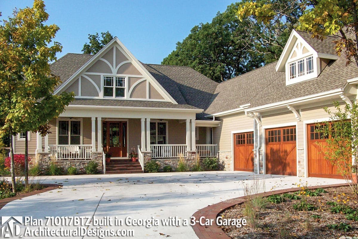 House plan exterior with a deep covered front porch, decorative gables, and a 3-car garage.