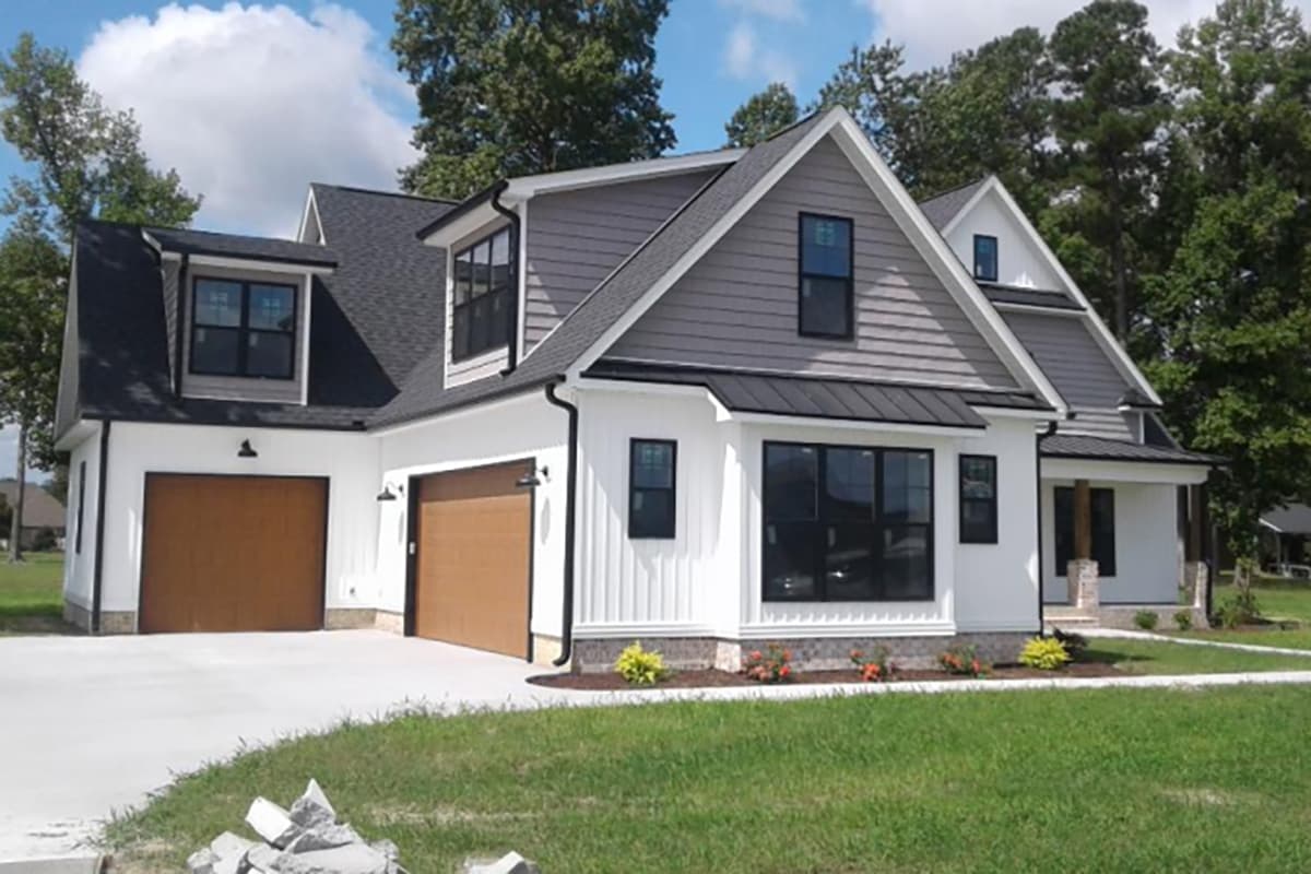Modern Farmhouse house plan exterior with a two-car garage, dormers, and mixed siding.