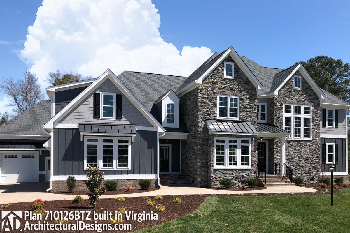 House plan exterior with stone and siding facade, prominent gables, dormers, metal awnings, and attached garage.