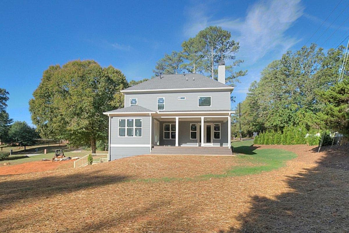 House plan exterior: two-story home with covered porch, multiple gables, dormer window, and stone chimney.