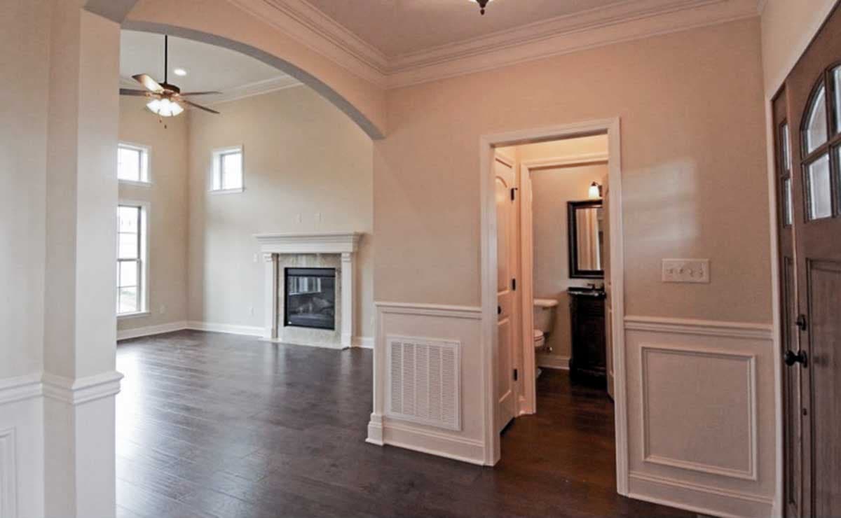 Interior view of house plan showing great room with vaulted ceiling, fireplace, and doorway to bathroom.