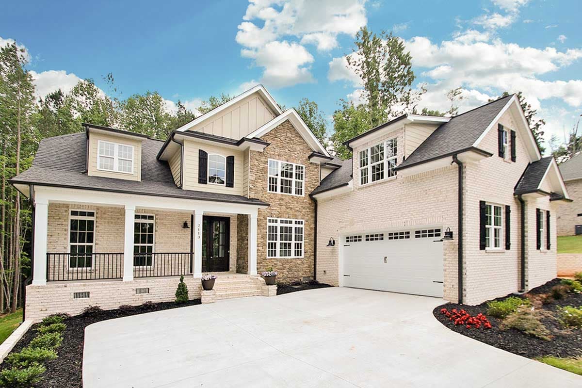 House plan exterior: Two-story home with covered front porch, stone accents, dormers, and attached two-car garage.