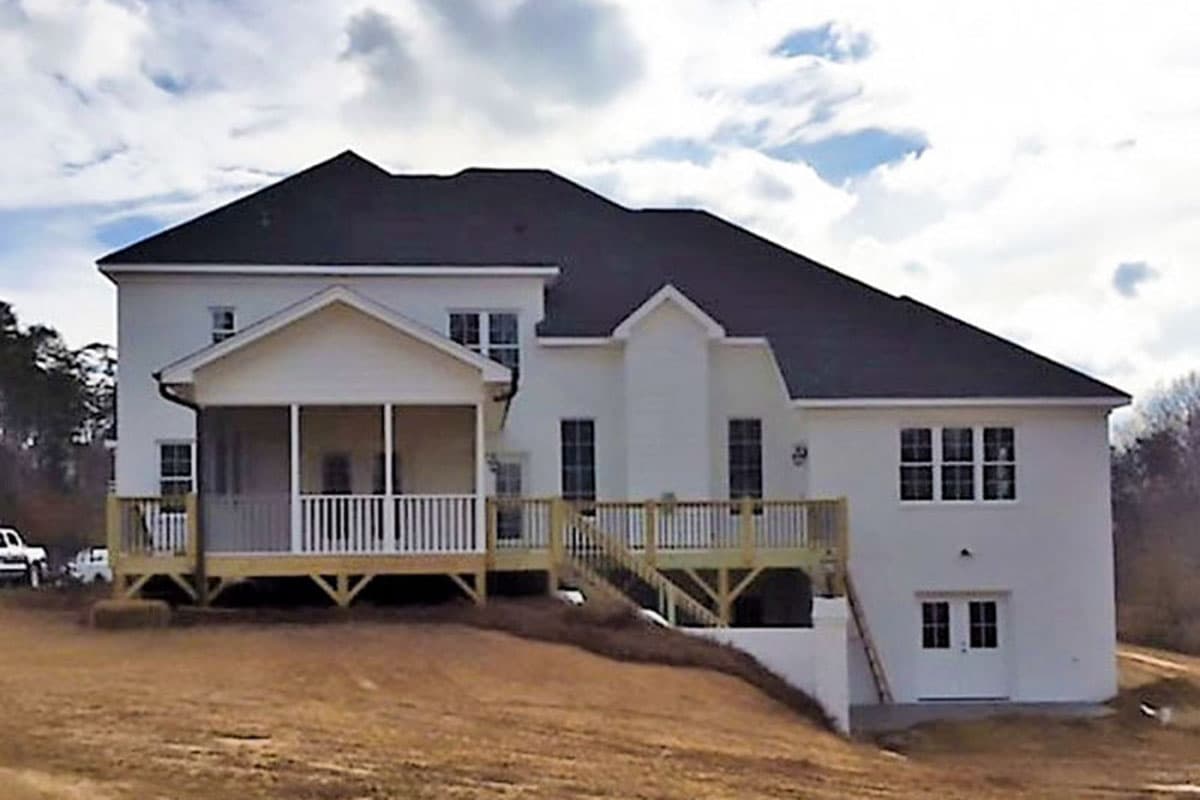 House plan exterior: Two-story dwelling with a screened porch, wrap-around deck, and gable roof.