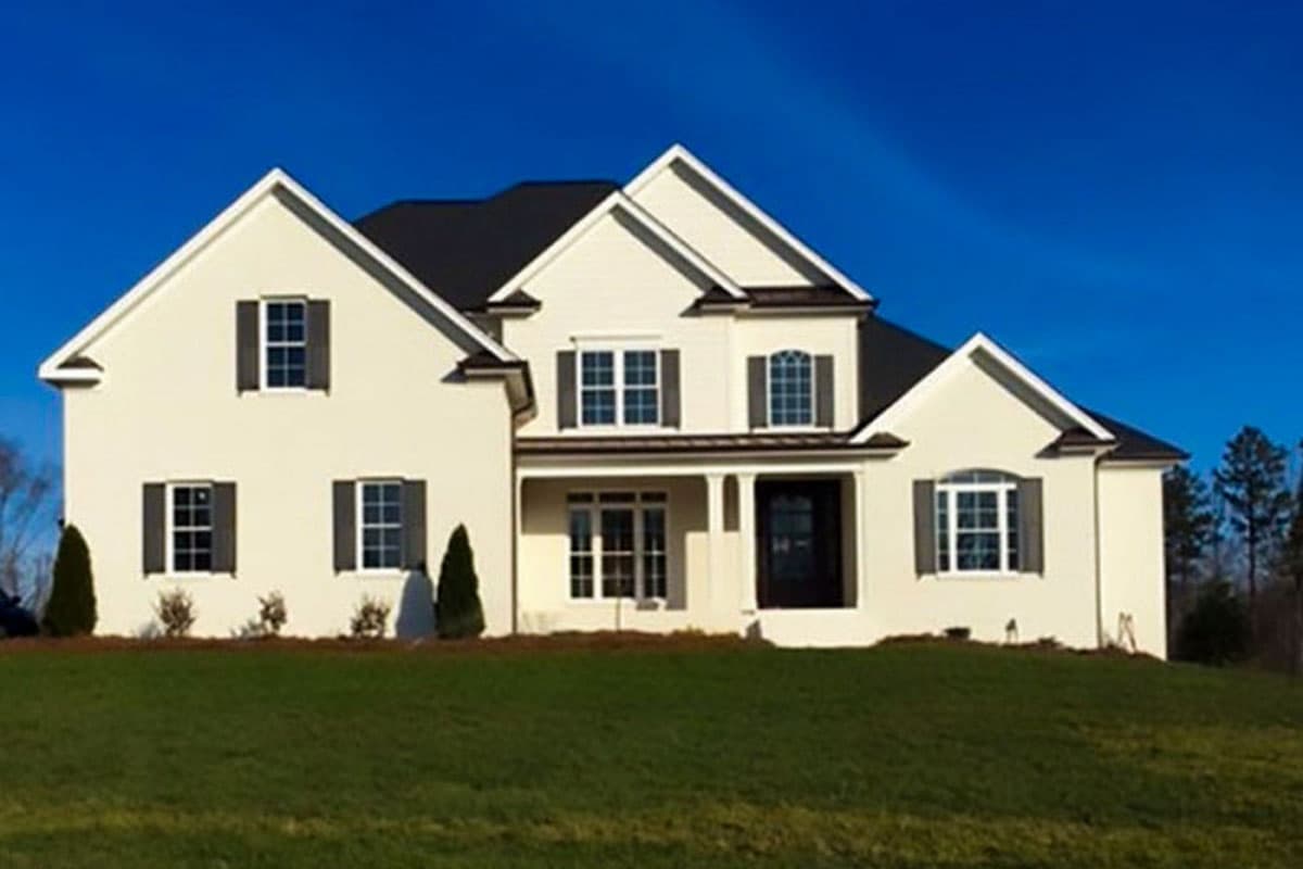 House plan exterior: Two-story home with a covered portico, multiple gables, and white stucco siding.