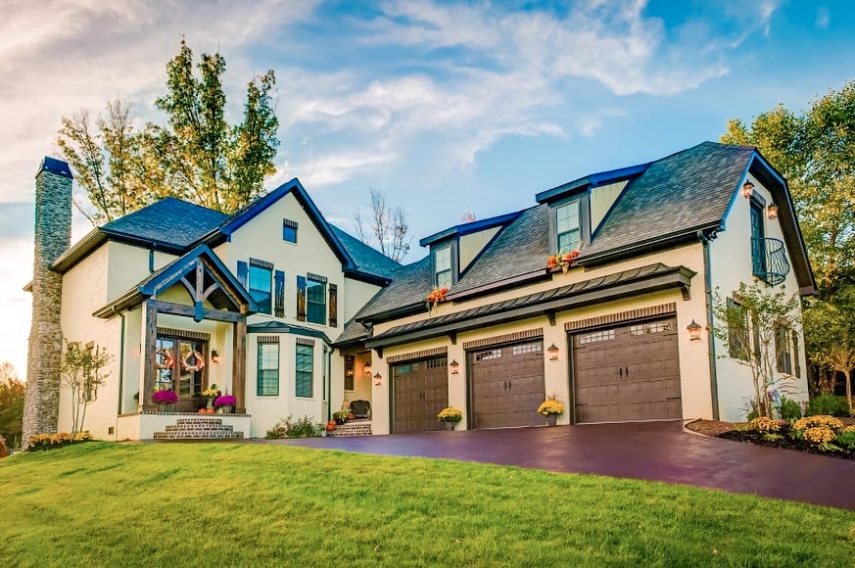 House plan exterior with multi-car garage, multiple dormers, brick chimney, and Craftsman style entry porch and gables.