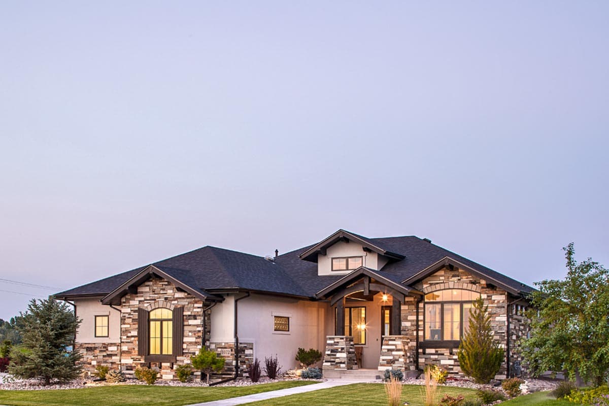 House plan exterior showcasing a single-story home with stone accents, gabled rooflines, and a covered entry with stone pillars.