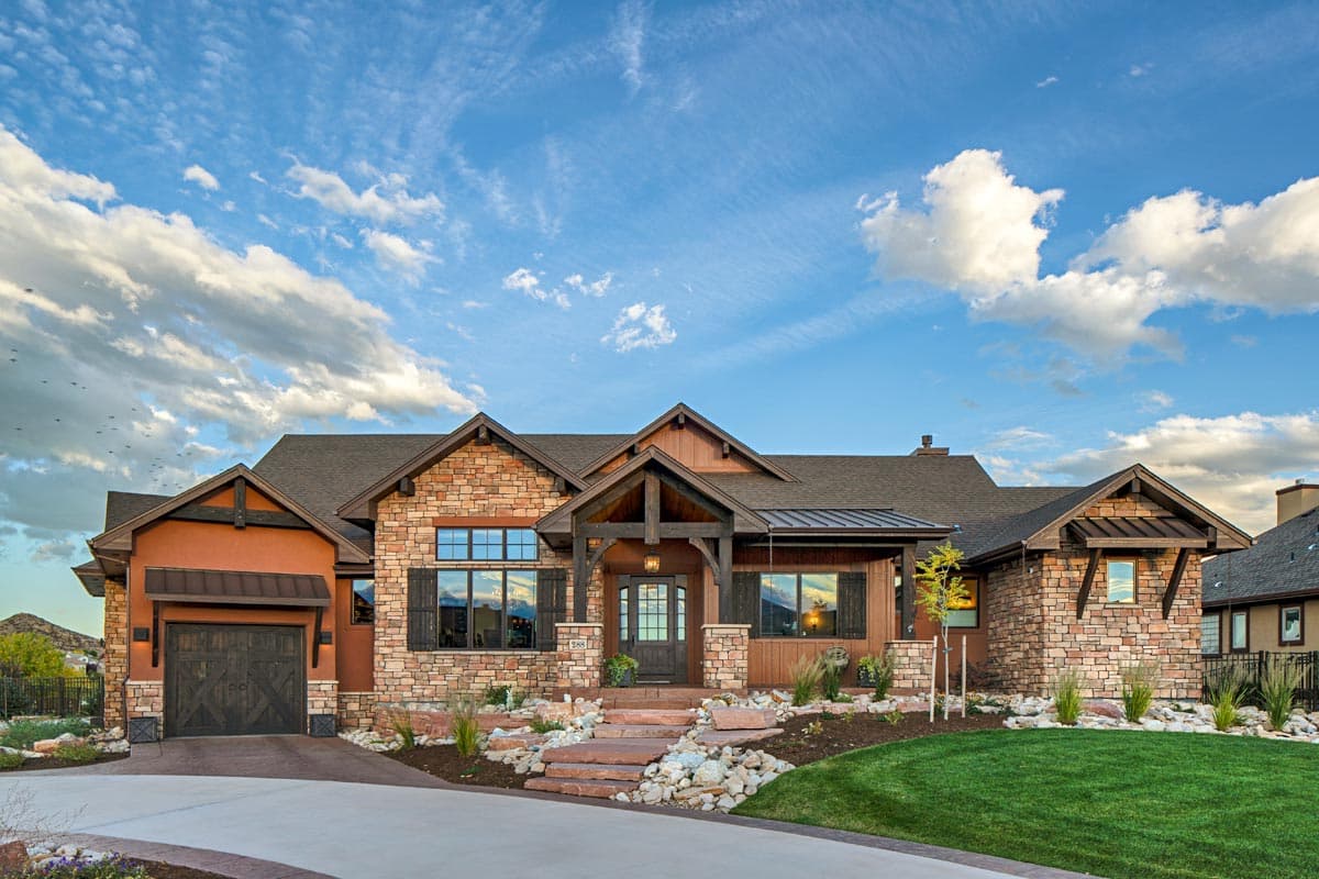 House plan exterior with stone facade, wood trim accents, gabled rooflines, and a side-entry garage.