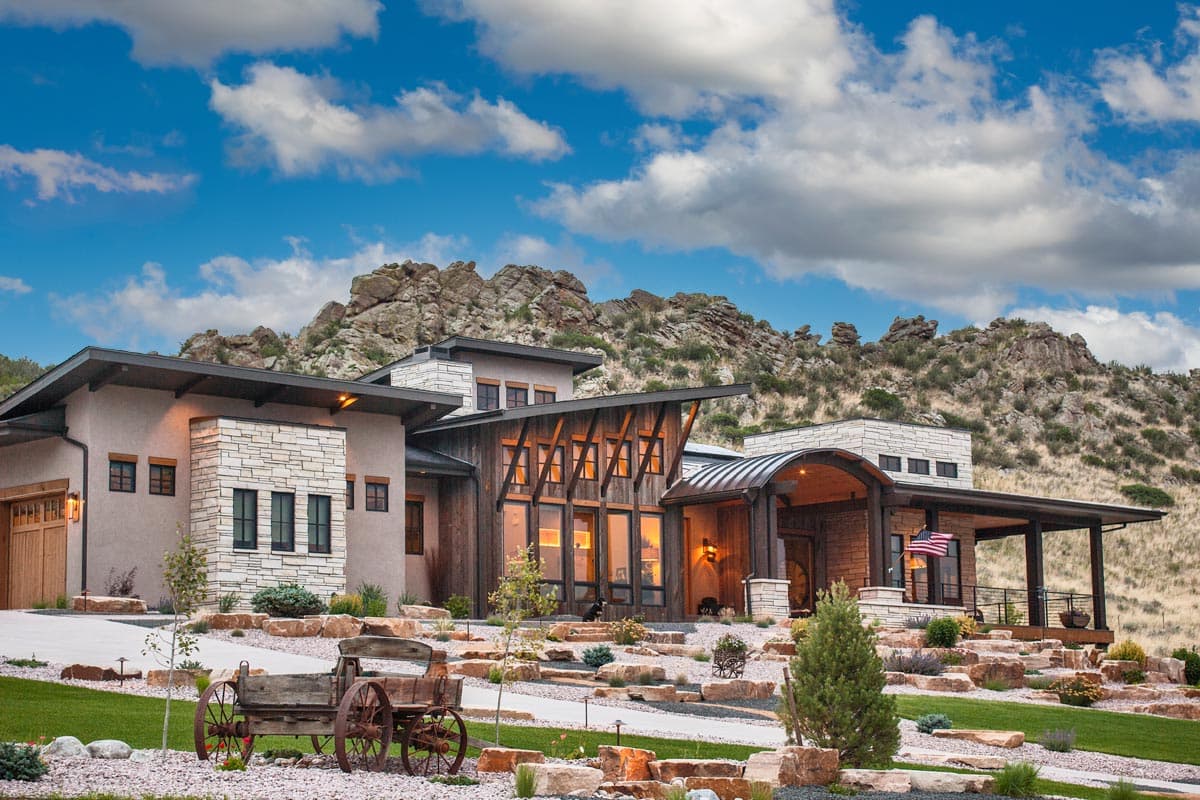 House plan exterior with modern design. Features include multiple rooflines, wood accents, an arched entry, and a covered porch.