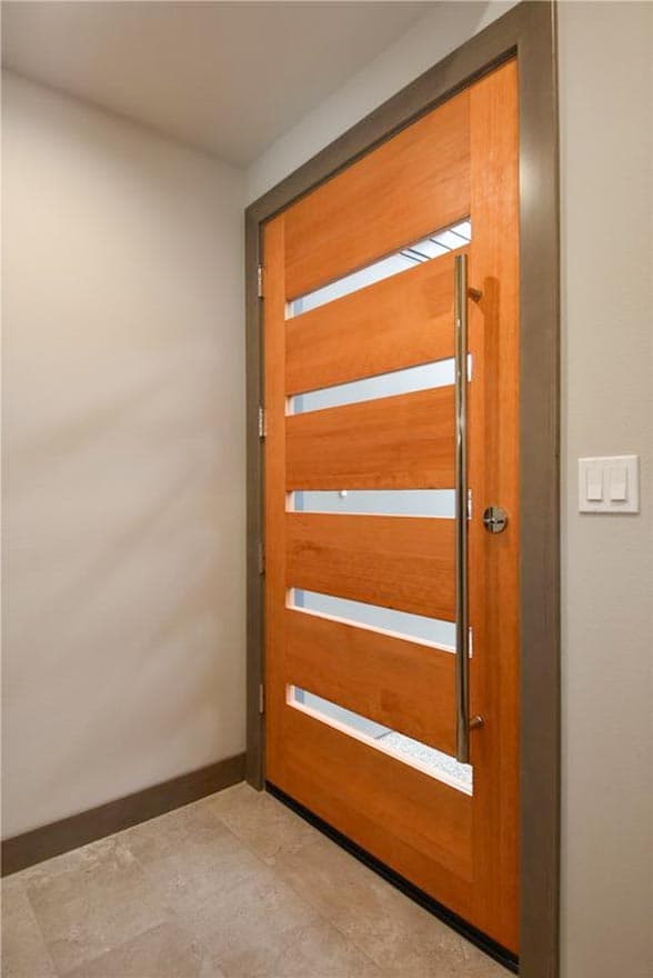 Modern wood entry door with horizontal glass insets and a brushed metal pull bar.