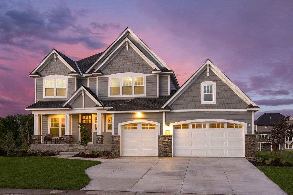 Two-story house plan exterior with gables, stone-clad porch columns, and a three-car garage.