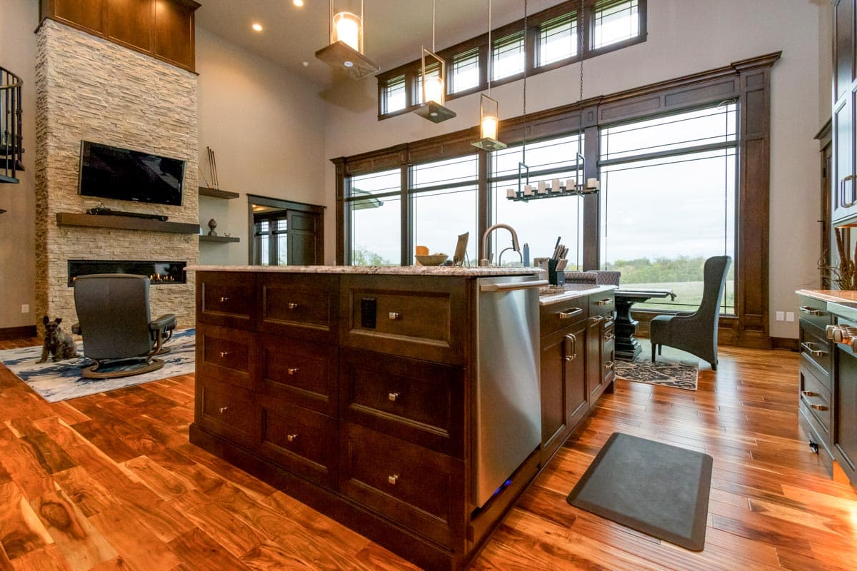 Great room interior with stone fireplace, wood island, and large windows with transoms.