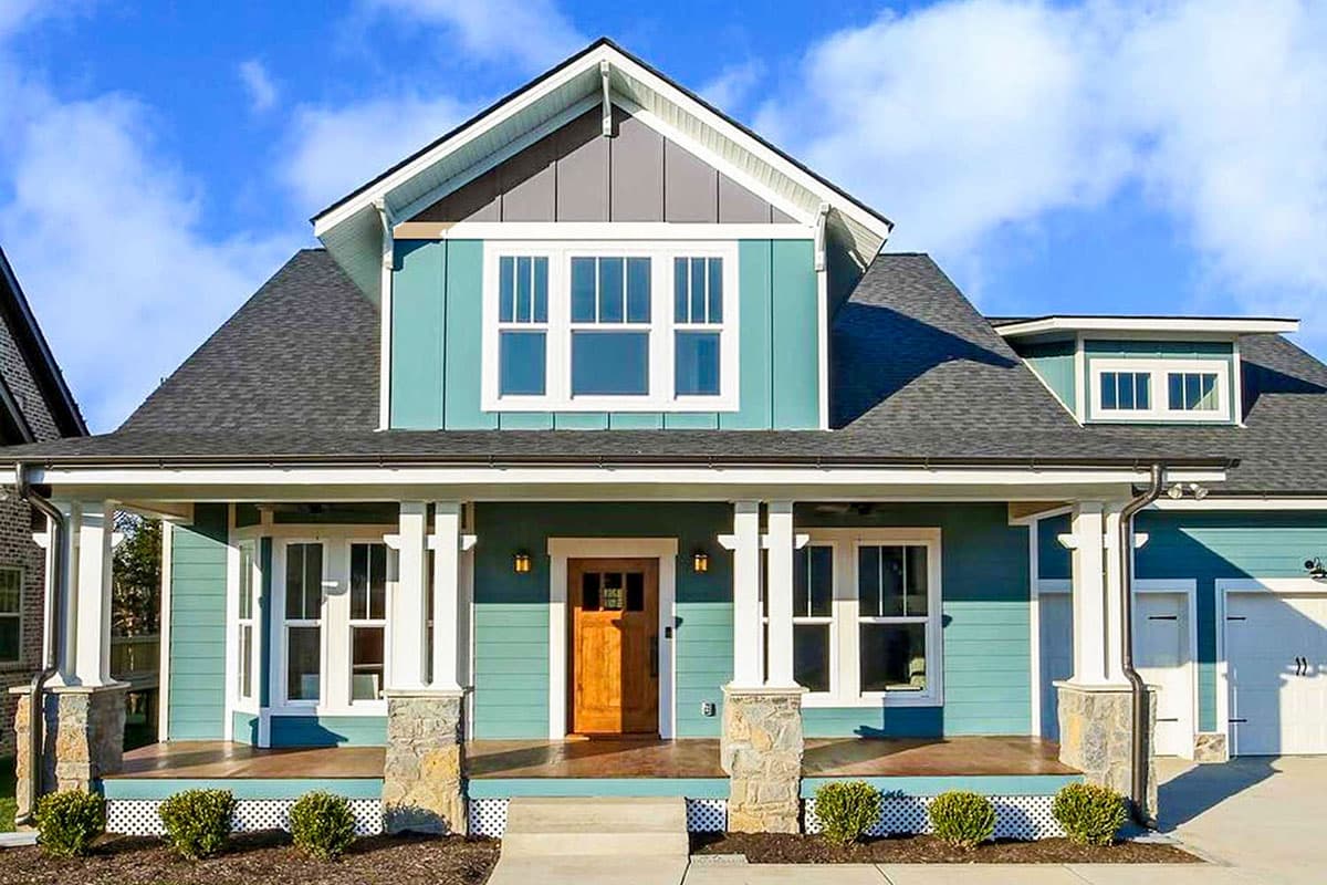 House plan exterior. Two-story Craftsman home with a front porch, gables, dormer windows, and a detached garage.