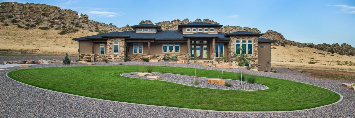 Modern house plan exterior with a flat roof, stone accents, prominent entry, and multiple gables.