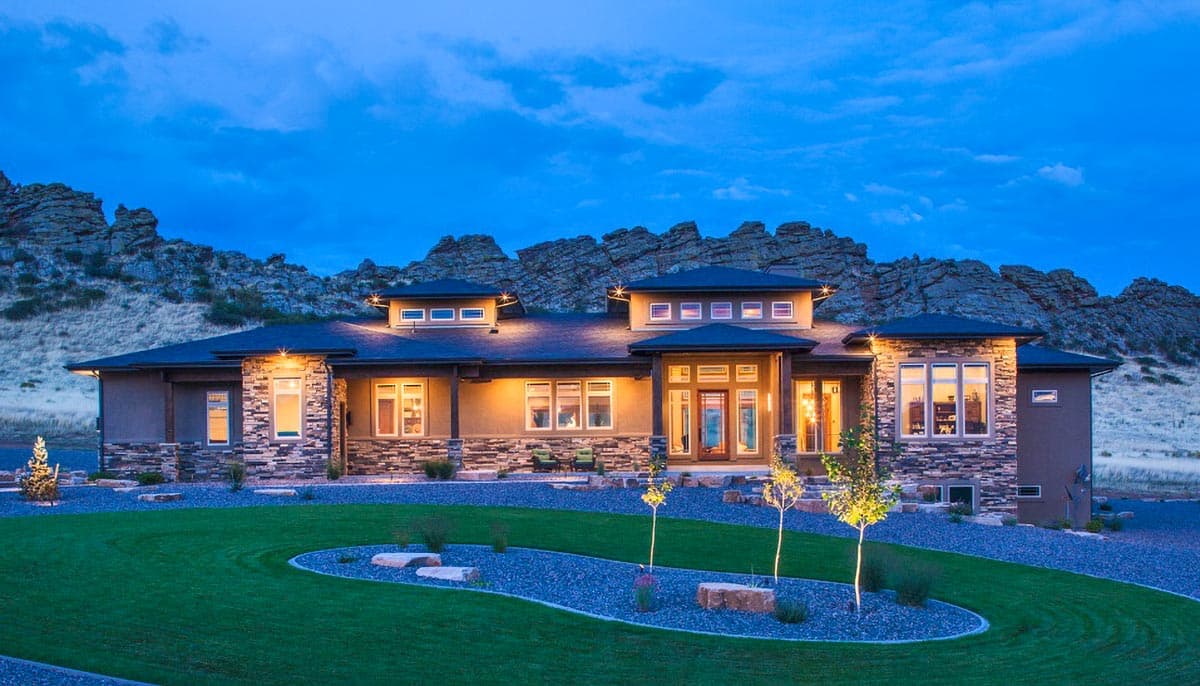 Modern house plan exterior with stone accents, flat rooflines, multiple dormers, and large windows.