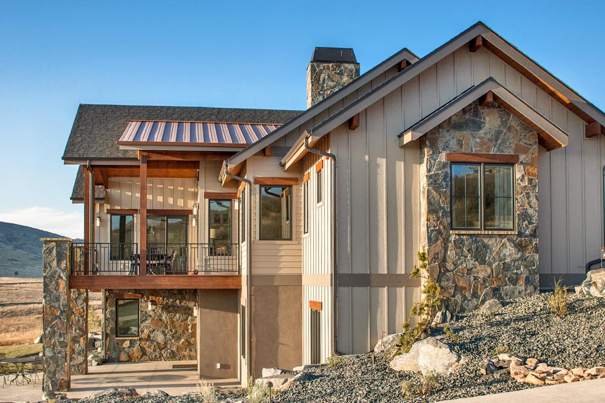 House plan exterior: Modern mountain style with stone accents, multi-level decks, and exposed rafter tails.